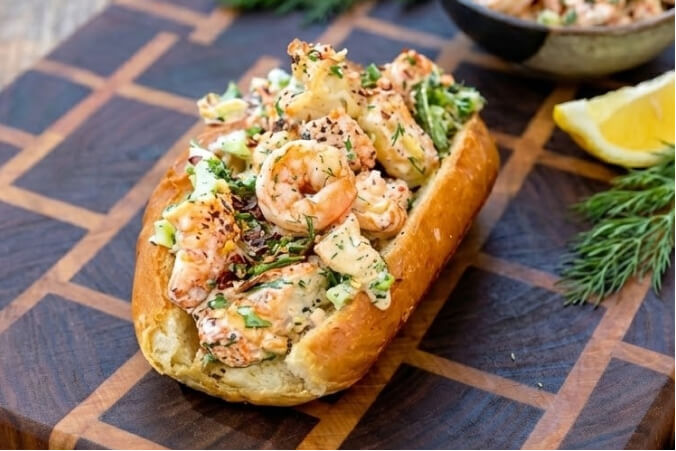 two Zesty Grilled Shrimp Rolls. The toasted split-top buns are overflowing with grilled shrimp tossed in a creamy, zesty dressing with fresh green herbs