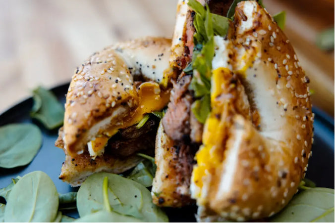 Coffee-rubbed Steak, Egg, and Spinach Bagel featuring sliced steak seasoned with bourbon smoked coffee and chili powder rub