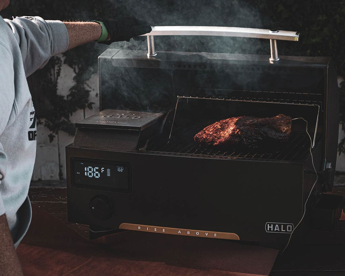 A man is looking over a brisket cooking inside the HALO Prime300 Pellet Grill
