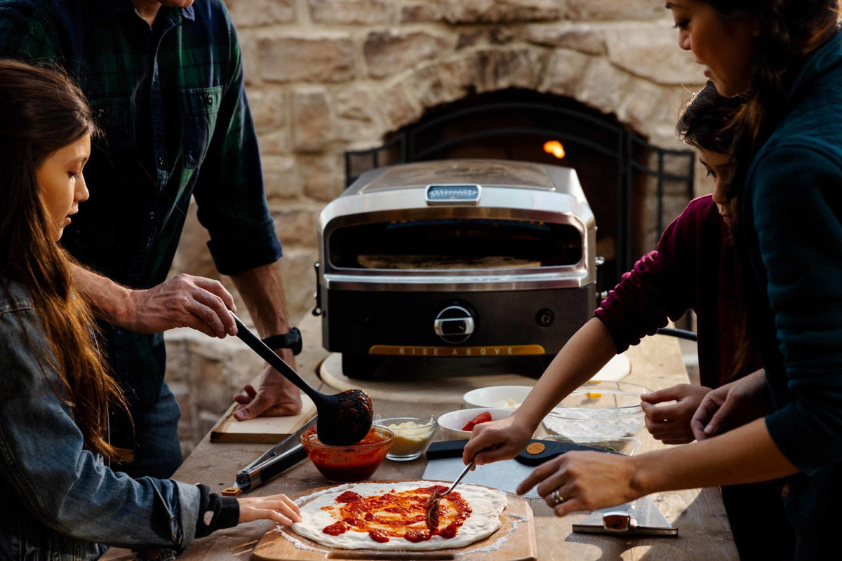 A couple enjoying a pizza from the HALO versa 16 pizza oven
