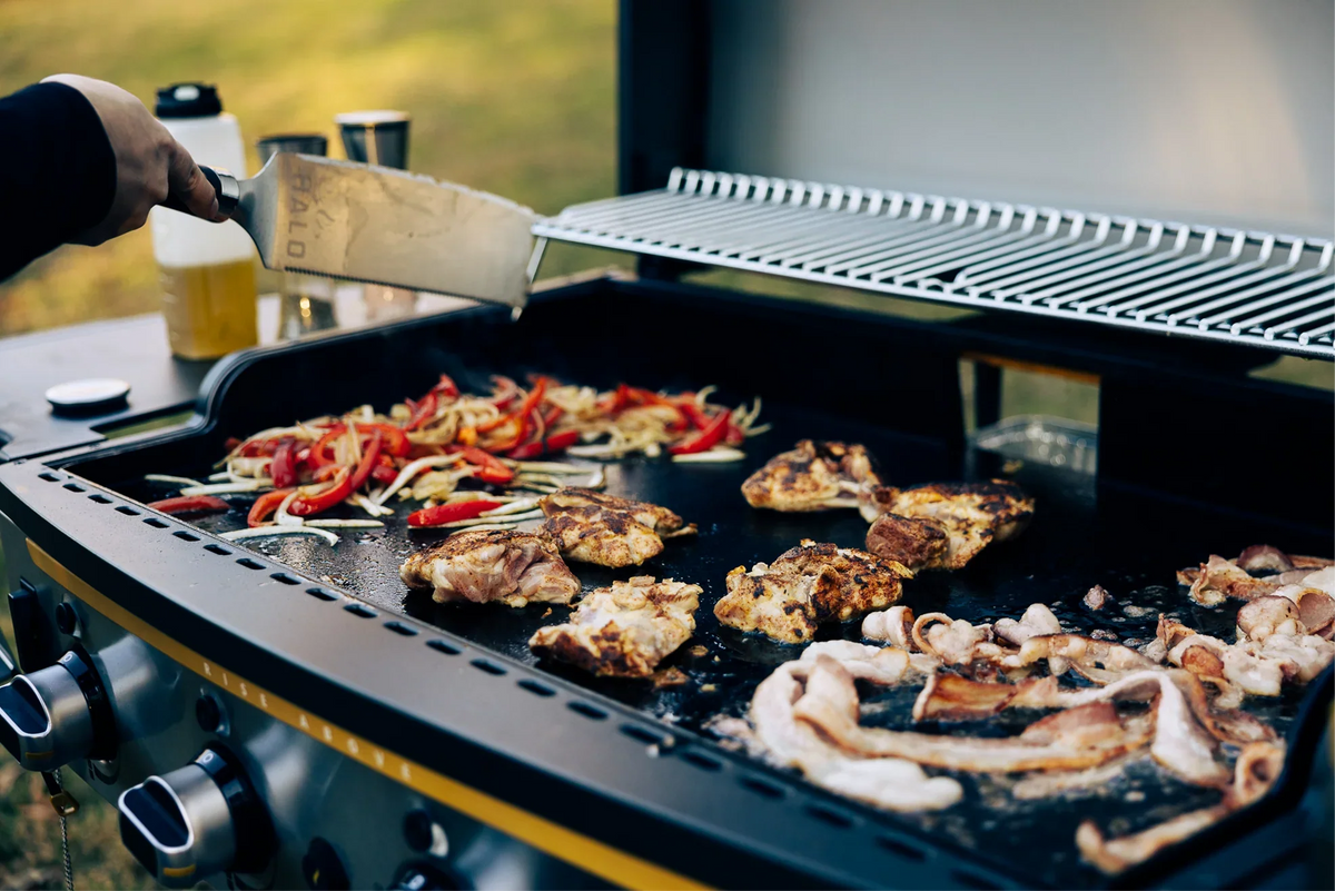 a man is grilling on an outdoor halo elite griddle