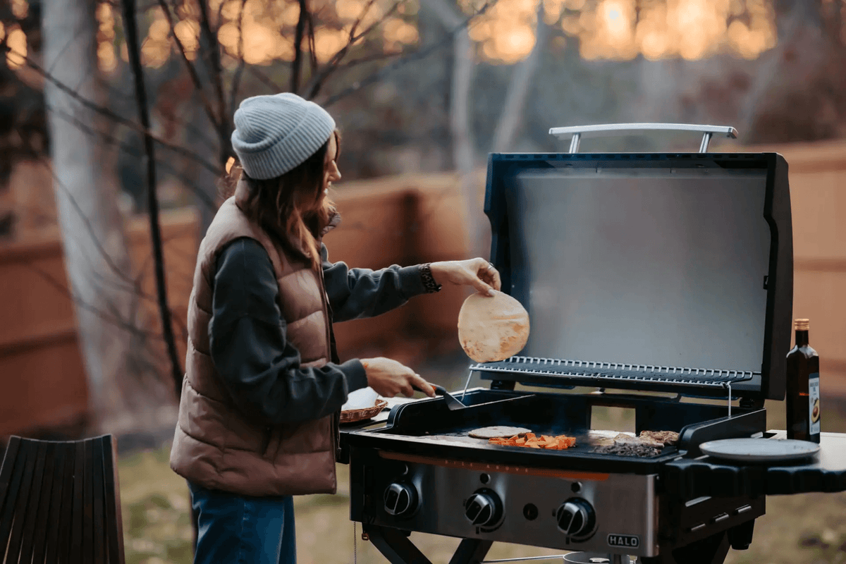 a man is grilling on an outdoor halo elite griddle