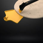 Using the removable scraper tip of a HALO brush to remove stubborn debris from a pizza stone.