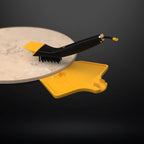 Close-up of a HALO scraper brush removing ash and debris from a pizza stone.