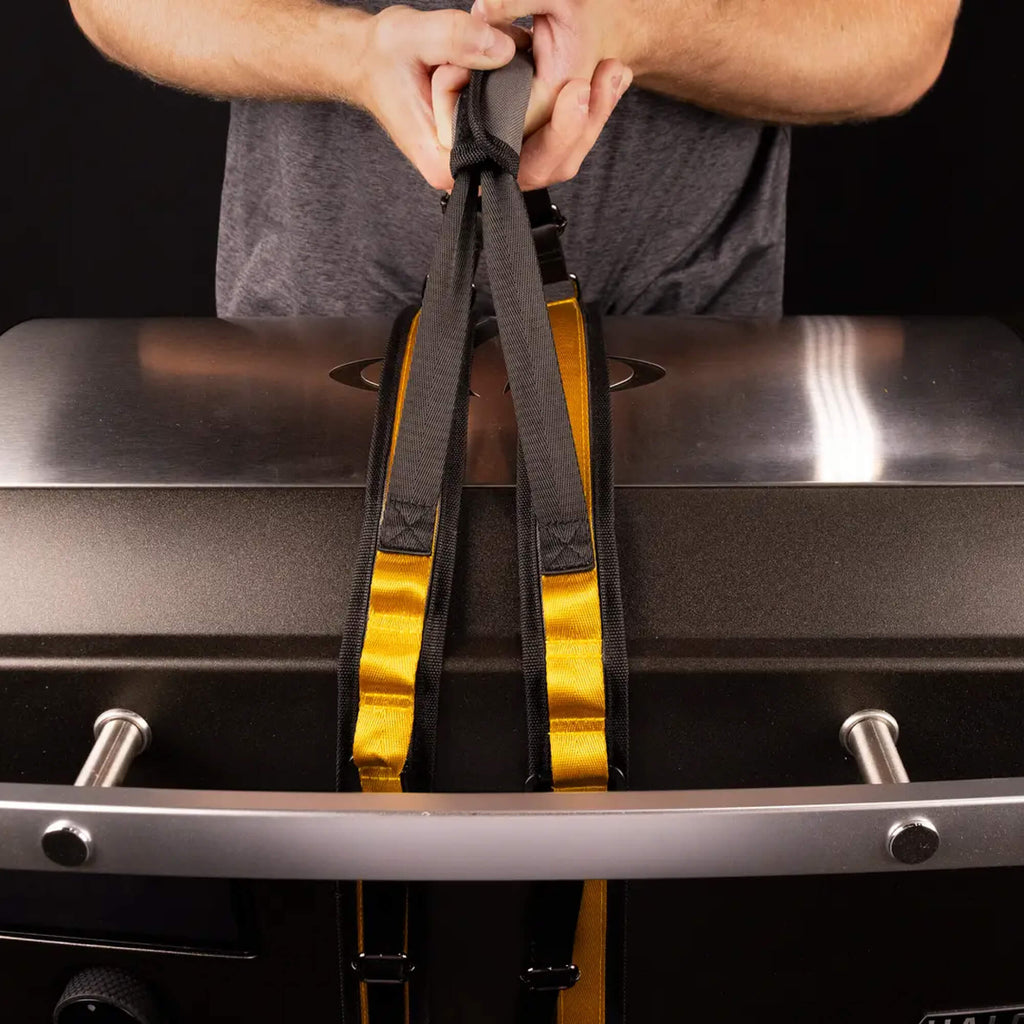 Person using HALO countertop appliance carrying straps to lift a griddle.