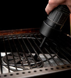 Close-up of the HALO Burn Pot Attachment being used to vacuum ash directly from the pellet grill
