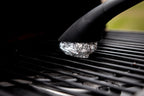 Using a specialized HALO handle to clean grill grates with crumpled foil for a deep-clean finish.