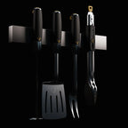 HALO grilling kit, including a spatula, fork, tongs, and pigtail flipper, displayed hanging by their ergonomic handles